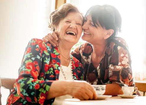 Two Happy elderly women laughing and hugging