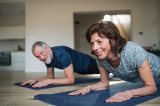 Older woman and man planking at home