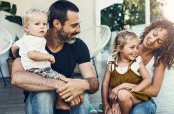 Photo of a couple with 2 kids sitting on the porch
