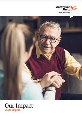 Elderly man in glasses and red vest warmly holds the hand of a young woman. Logo "Australian Unity" and text "Our Impact 2025 Report" visible.