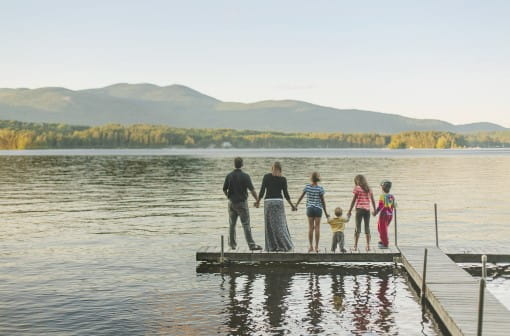 Family holding hands looking over lake