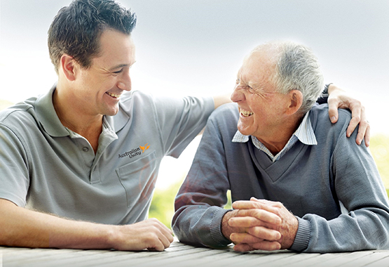 Image of a young man and an old man talking and laughing together
