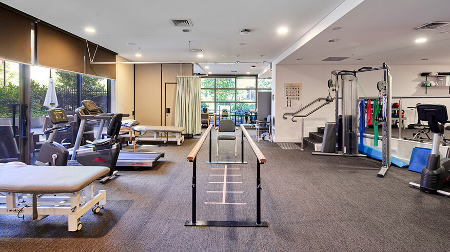 Gym with treadmill, exercise bikes and other exercise equipment. Gym is looking out to the garden.