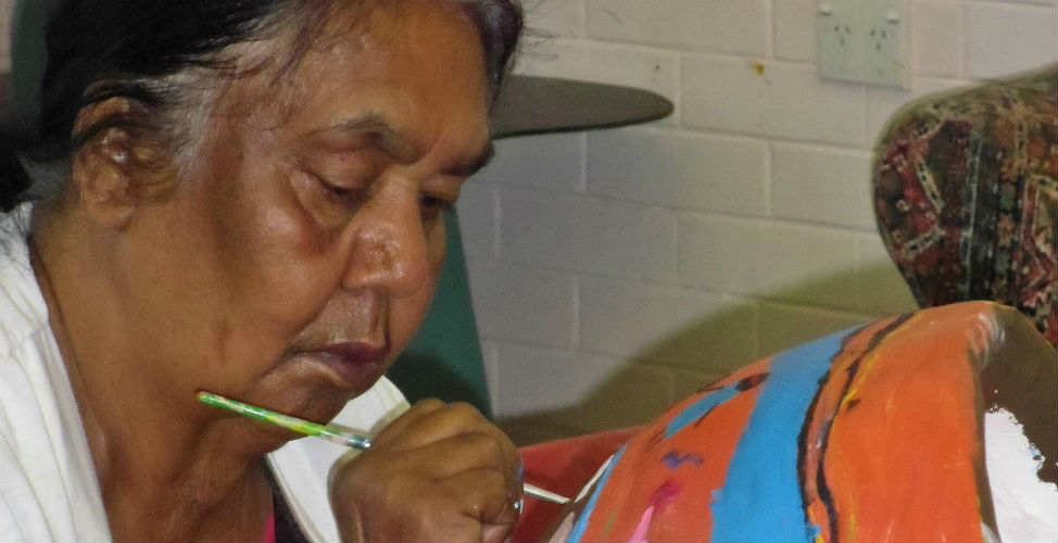 Aboriginal woman painting a belly cast