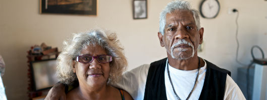 One Aboriginal man and women standing in a lounge room