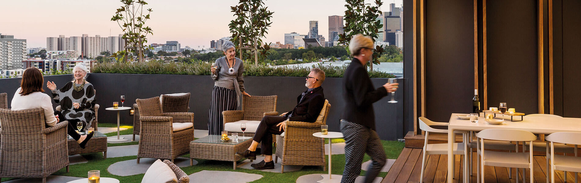Drummond Place outdoor terrace with a view of the skyline in the city in the background. Residents enjoying a drink on the terrace.