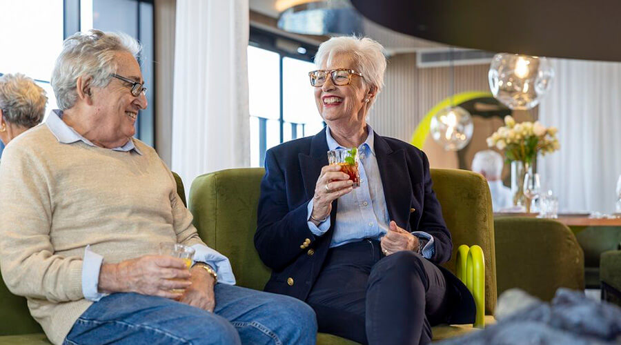 The Alba two male residents sitting together laughing