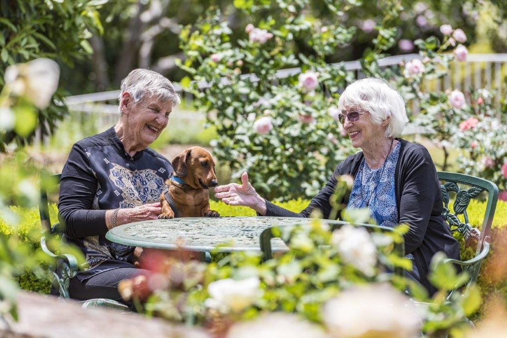 Two elderly people sitting on a table in the garden