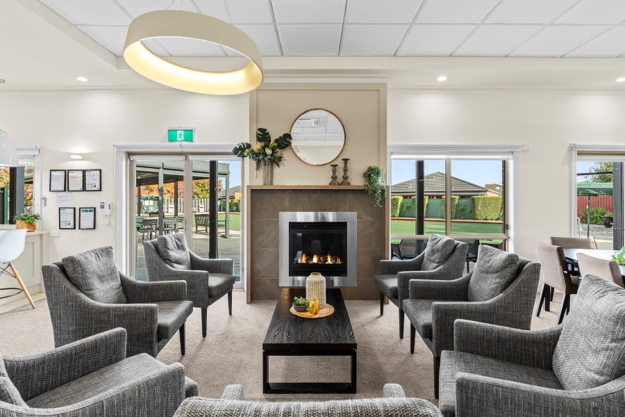 Modernly furnished common area in front of a fireplace