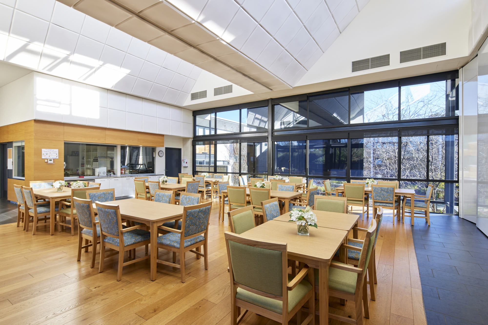 A spacious dining room featuring multiple tables and chairs arranged for guests.