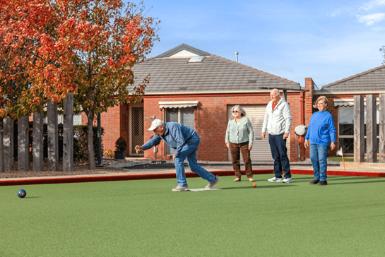 A group of elderly friends competing in bowls