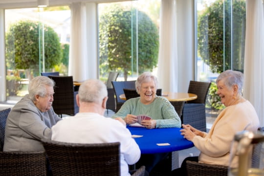 Group of older friends playing cards and laughing