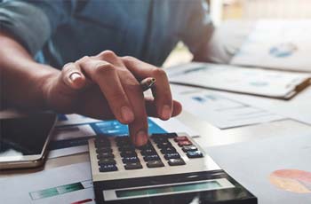 photo of person's hand using a calculator