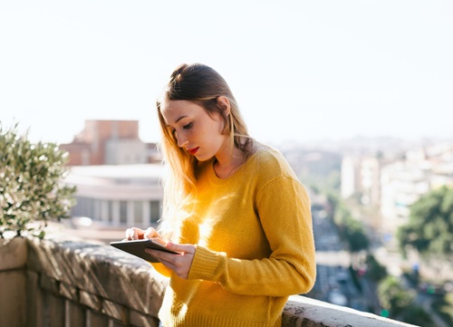 Woman on tablet standing outside