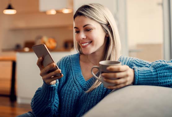 Image of a female smiling and looking at her phone