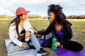 Two female friends sitting in a park