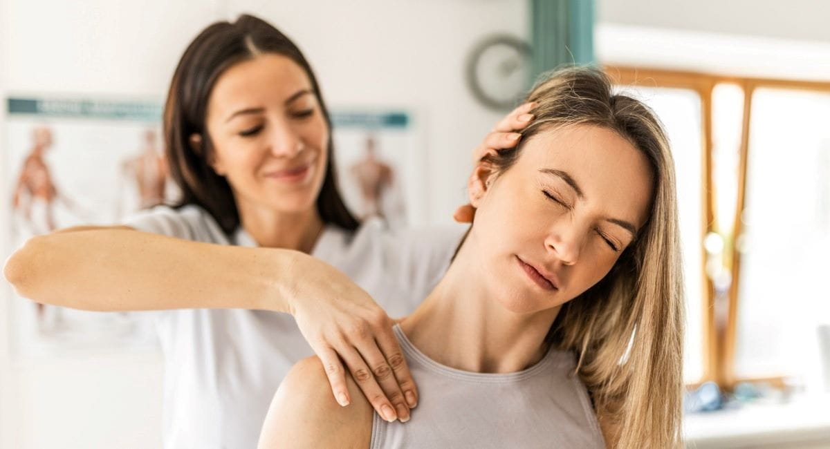 A young woman receiving physio treatment on her neck