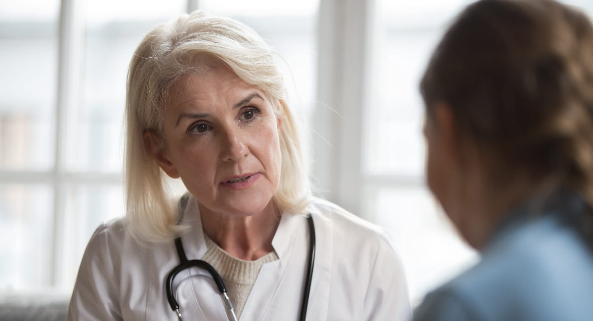 A health practitioner having a serious conversation with a patient off screen.