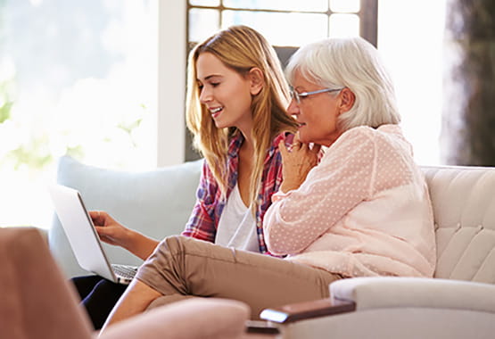 Elderly woman and grand daughter using a laptop together