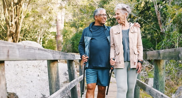 Man and woman walking together, laughing, on a bridge