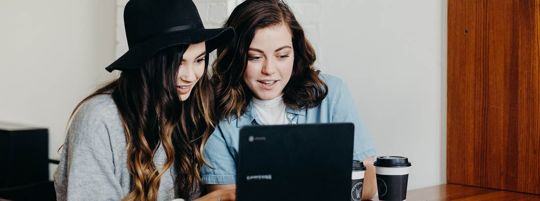 Two young ladies looking at a laptop