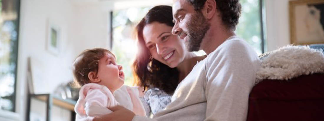 Father and mother holding and smiling at their baby