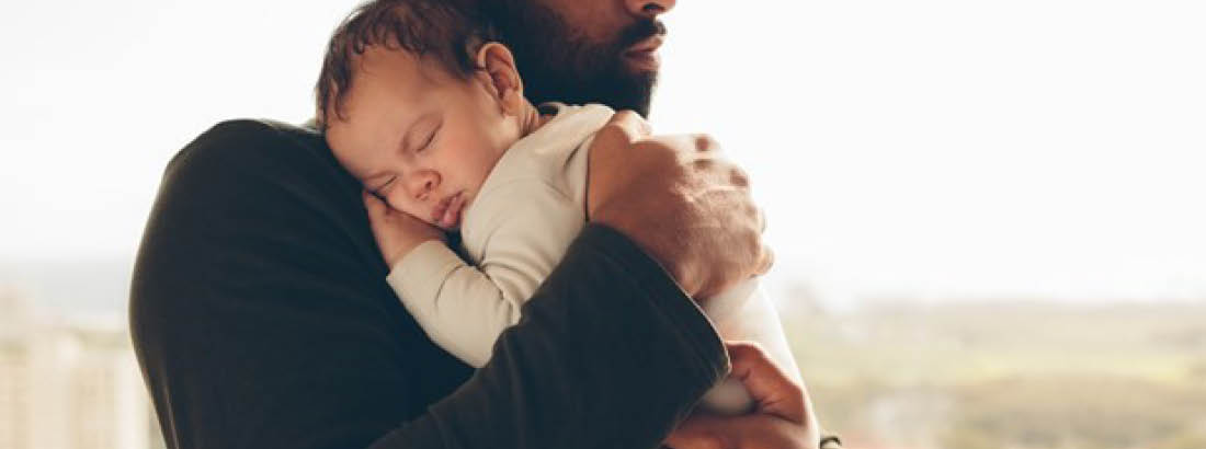 Father holding his young baby on his shoulder