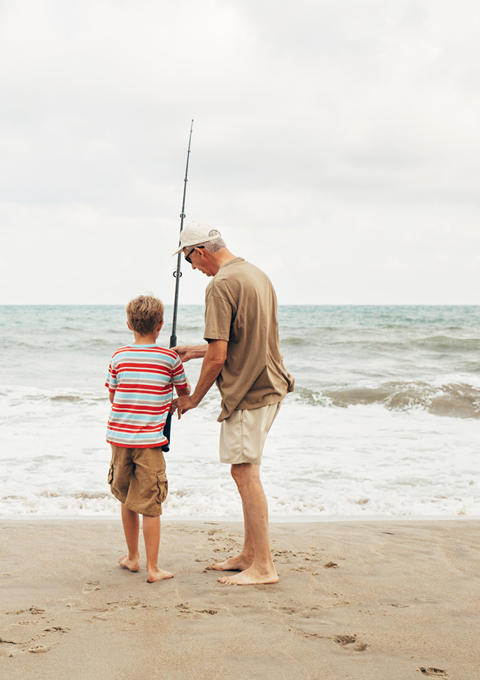 Man and boy fishing at beach