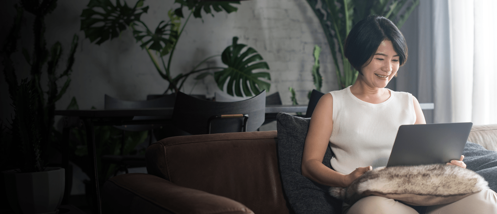 A person sitting on a couch, using a laptop
