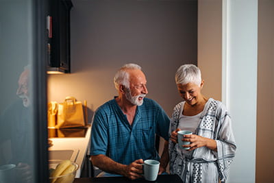 An older couple enjoying a coffee in the kitchen