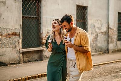 A younger couple out for a walk with icecream
