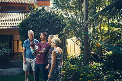 A family in a garden looking at a child.