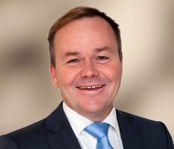 Portrait of Adam Vise, acting CEO of Wealth and Capital Markets, smiling at the camera. 