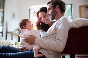 Father and mother holding and smiling at their baby