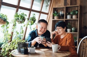 Two people at a table enjoying a cup of tea.