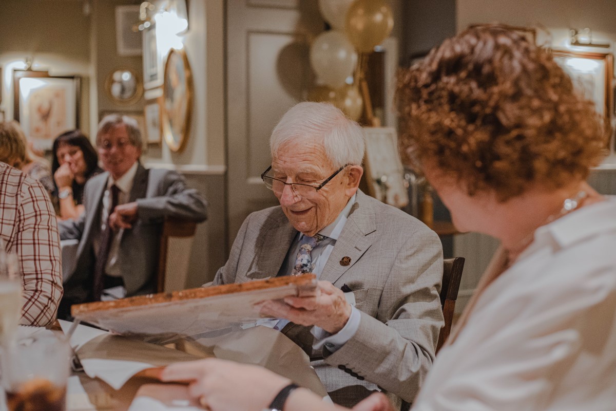 Older man unwrapping a picture frame