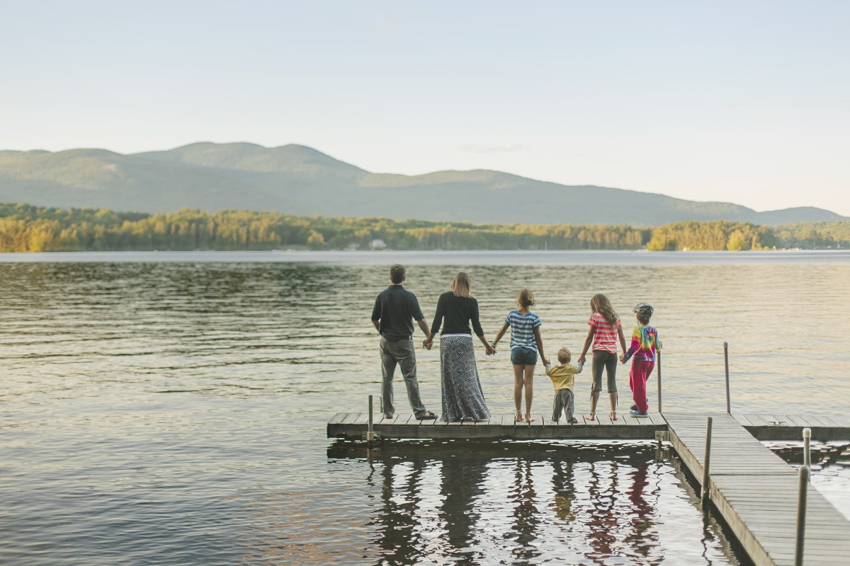 Family holding hands looking over a lake