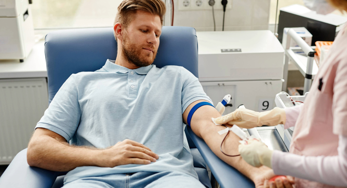 A man lying down and getting his blood drawn