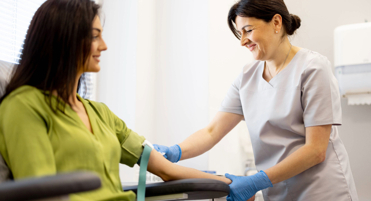 A woman getting her blood drawn by a nurse