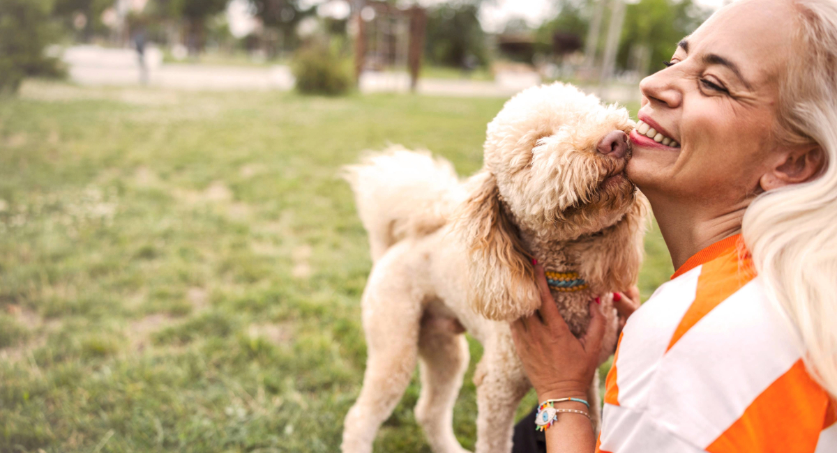 An older woman outside with her dog