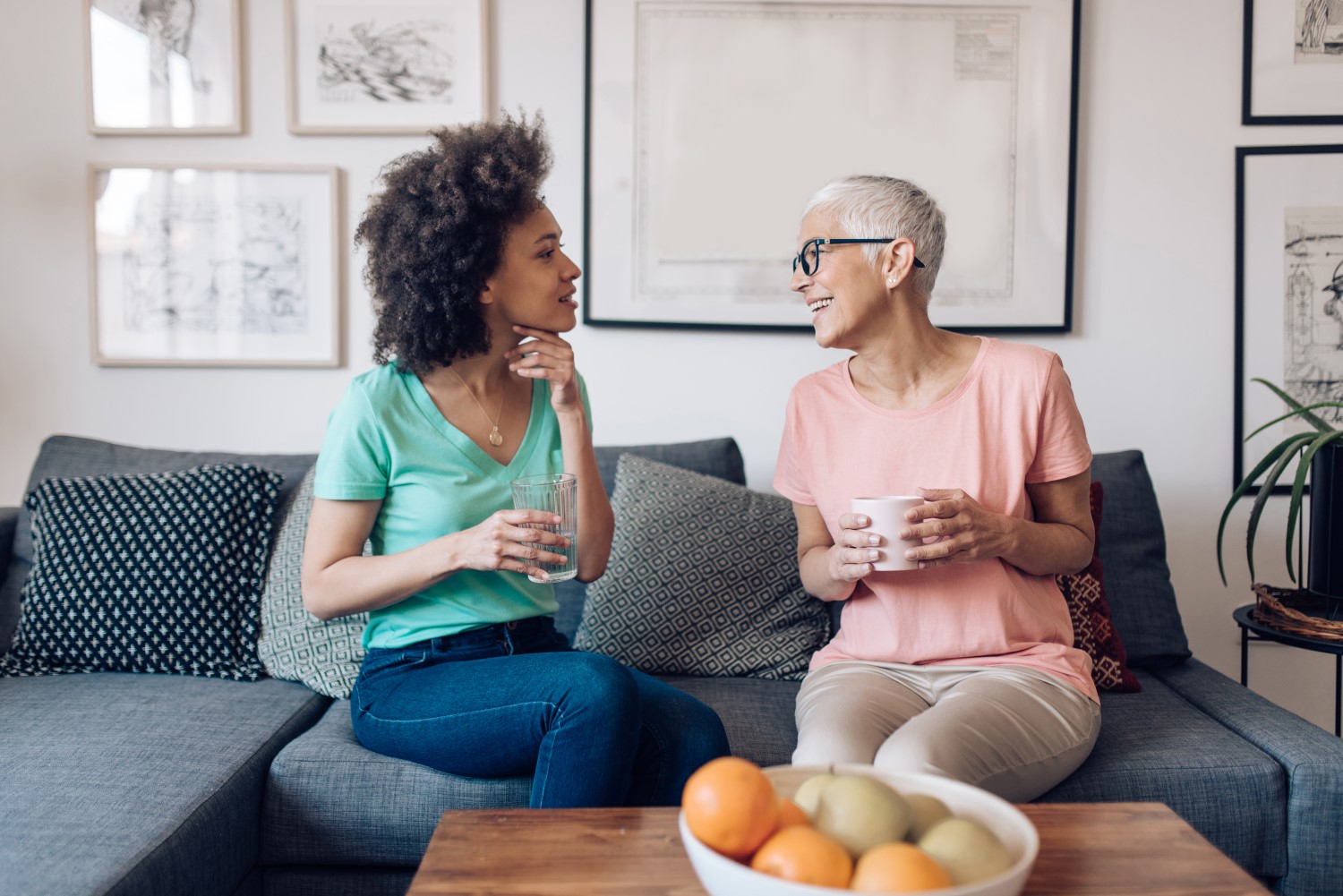 Two women having a serious conversation on couch