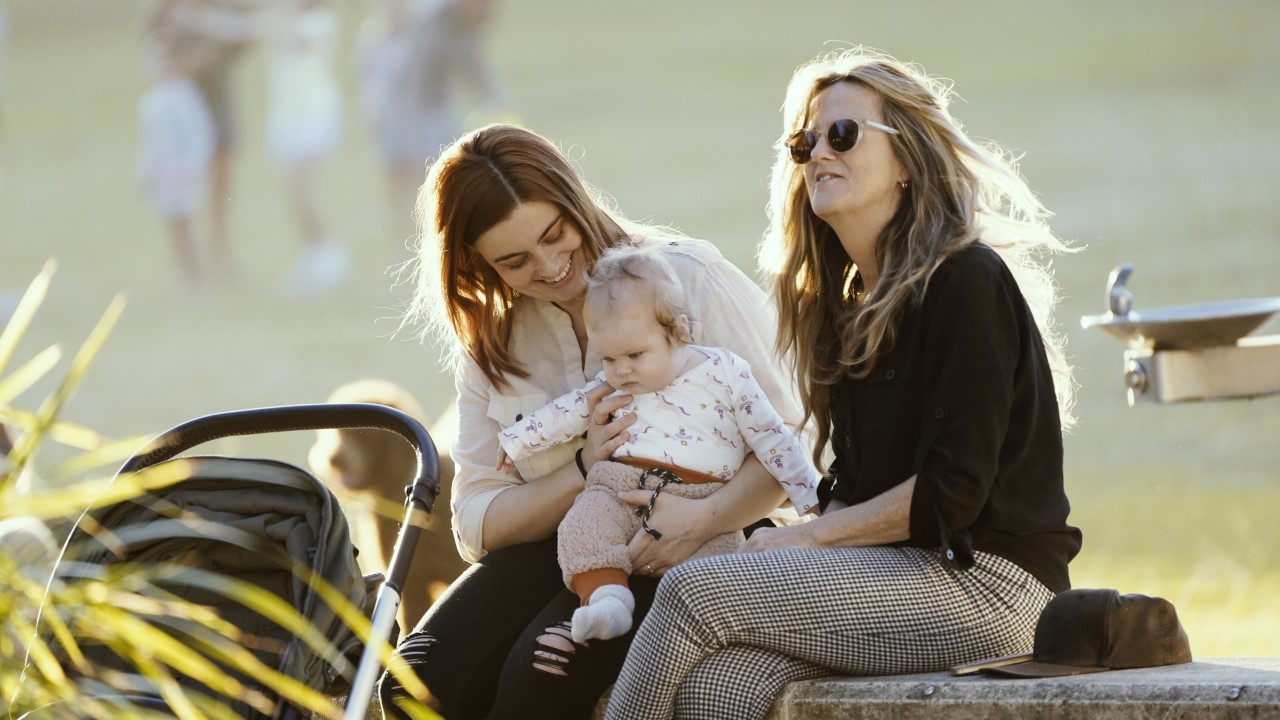 Two women with a baby in park