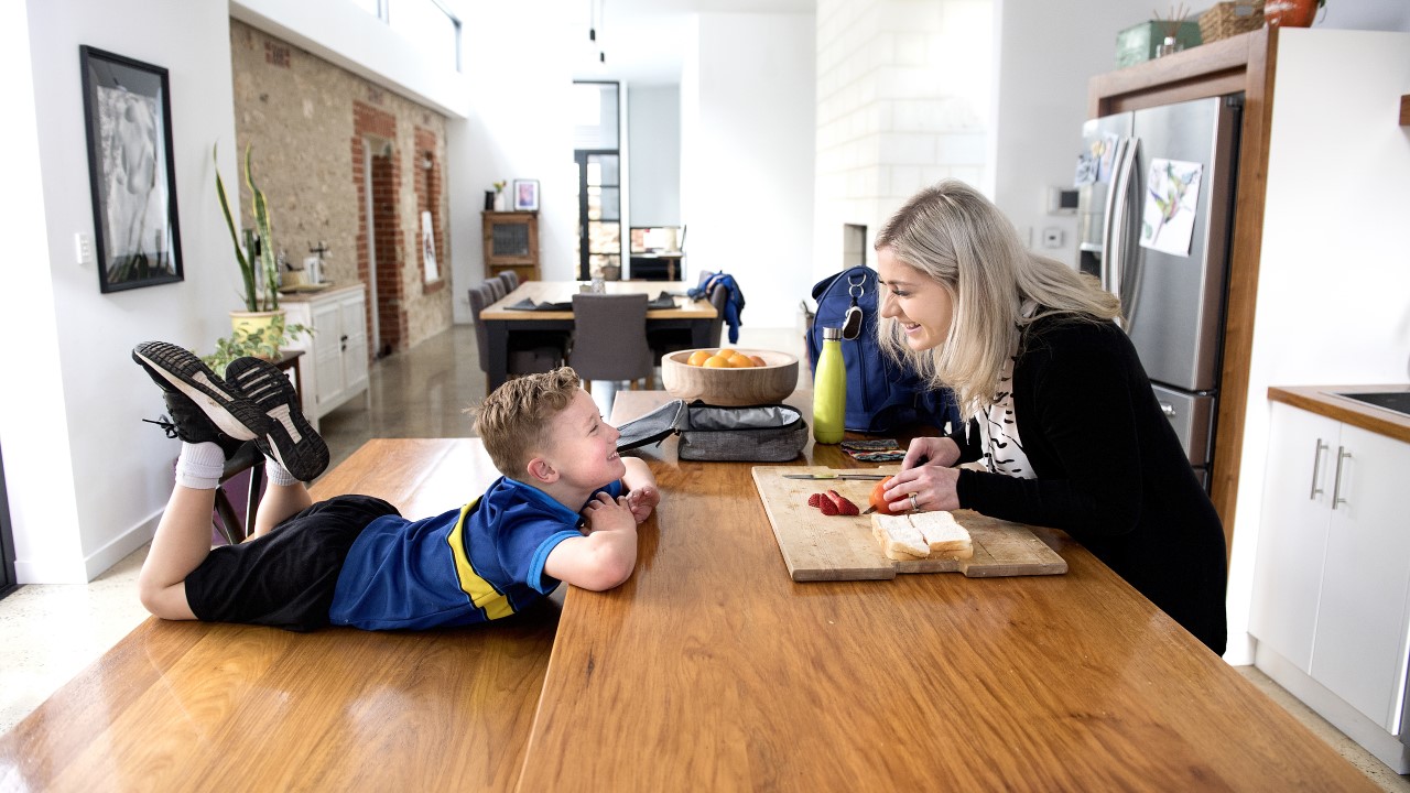 Mother happily talking to son at kitchen table