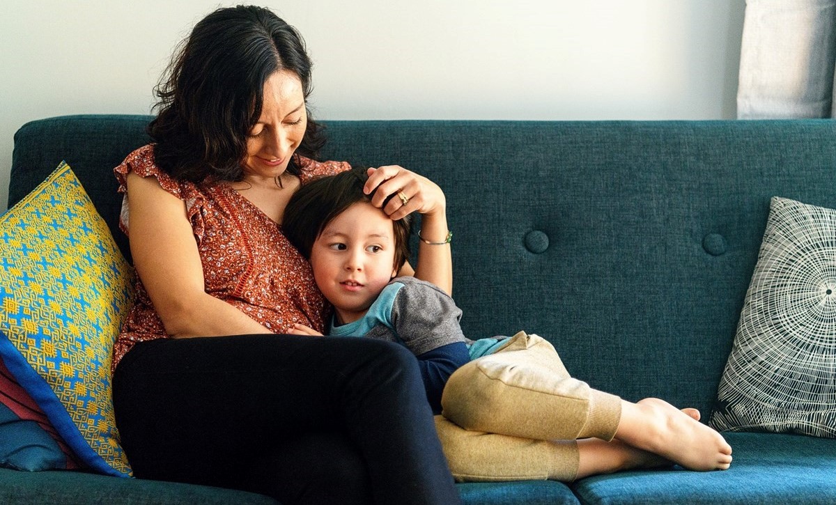 Mother and young child sitting on a couch 