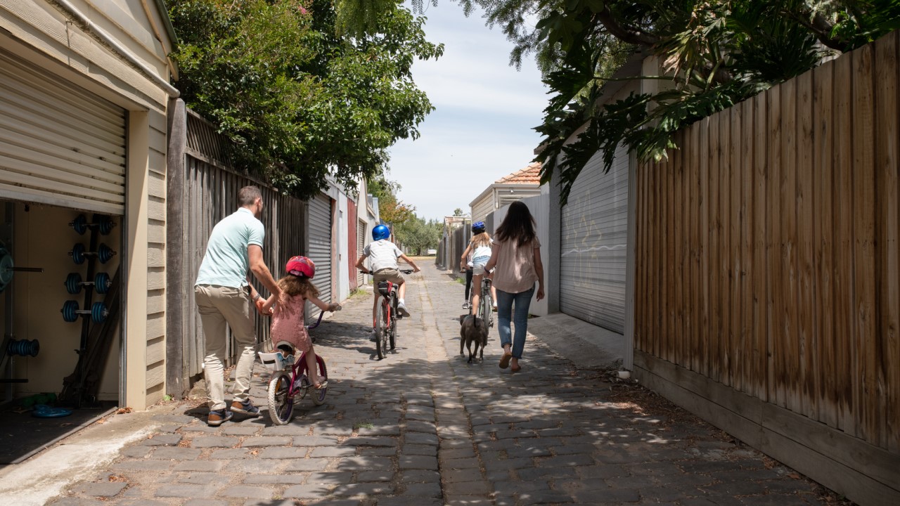 Family walking down bluestone laneway