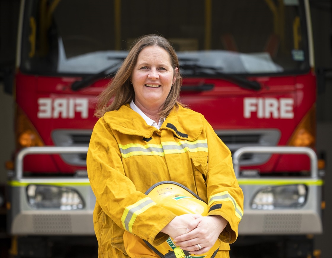 Tammy Meyer in her CFA uniform, standing in front of a CFA firetruck