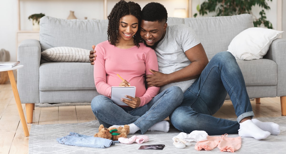 Pregnant woman and partner looking at baby items