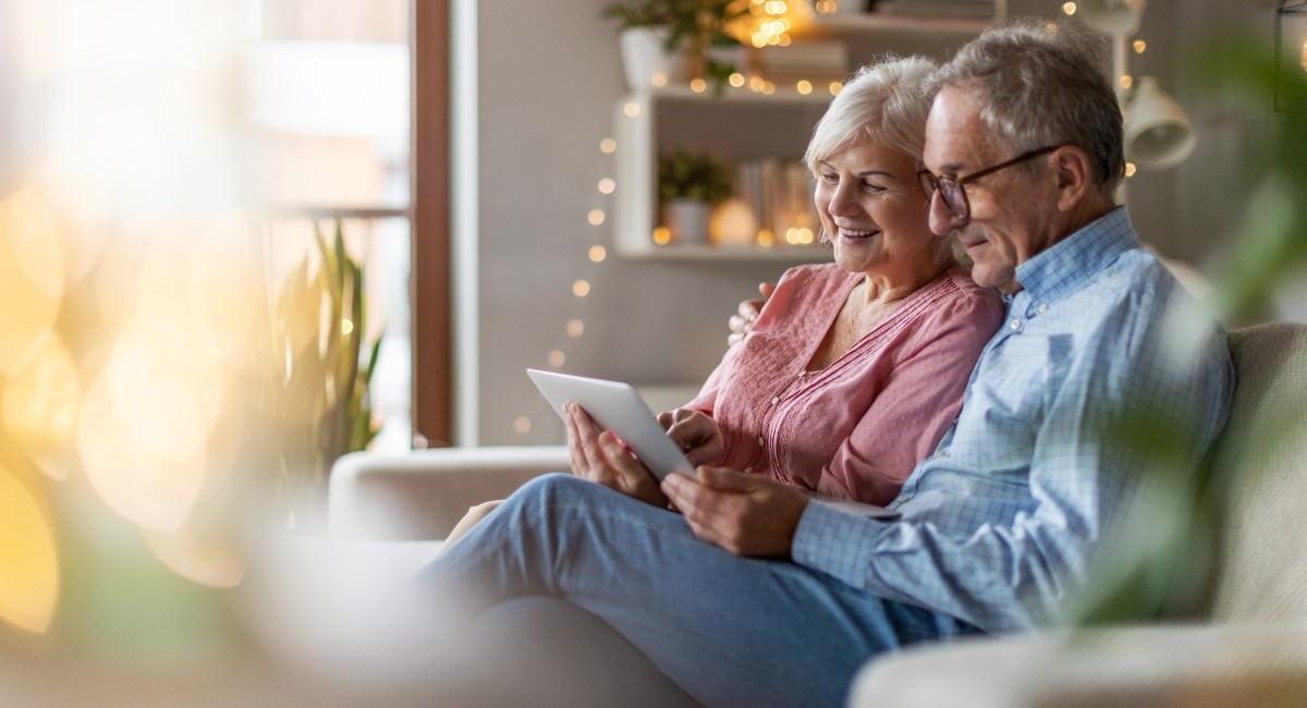 Older man and woman smiling and laughing at home