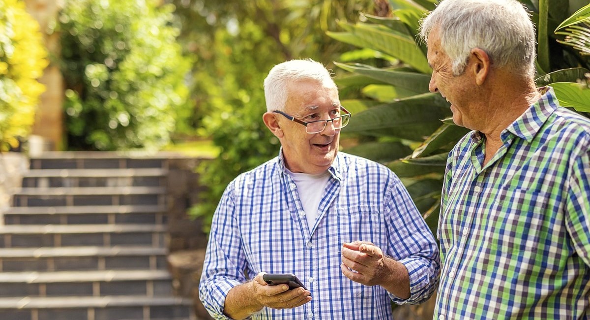 Two older men laughing and talking