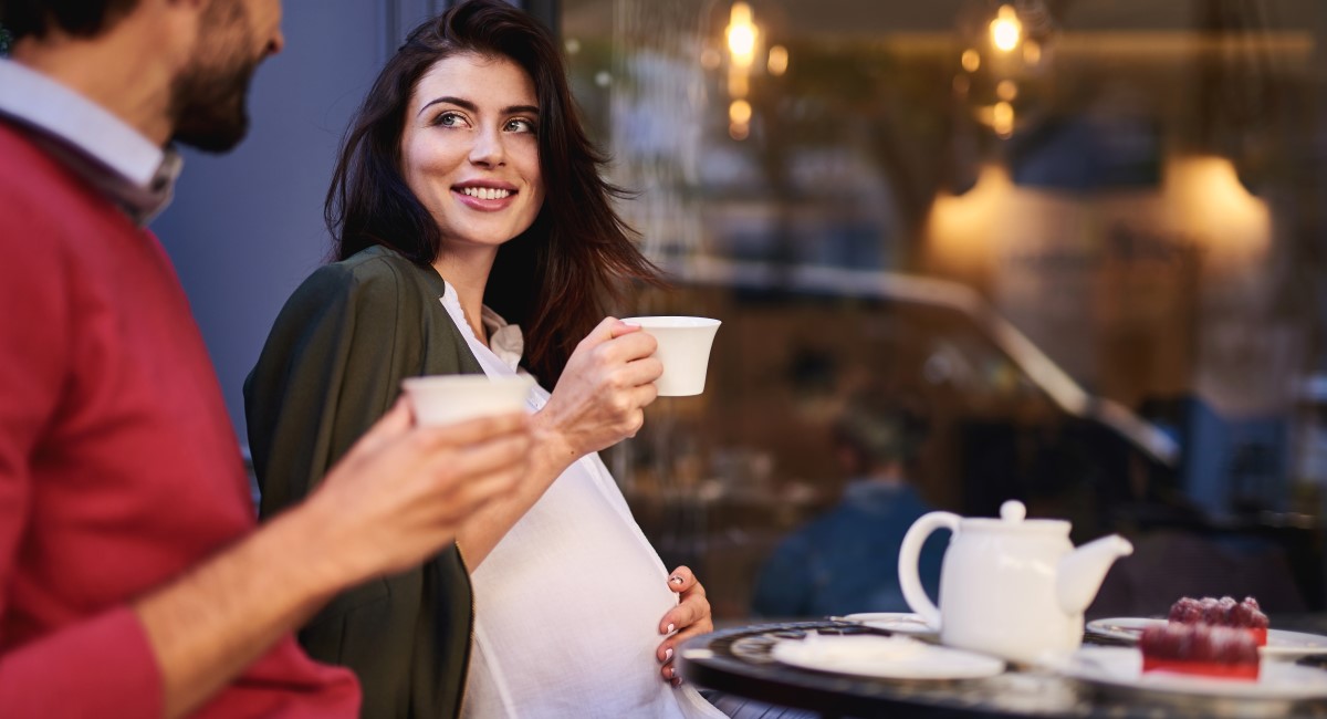 Pregnant woman having a cup of tea at a cafe